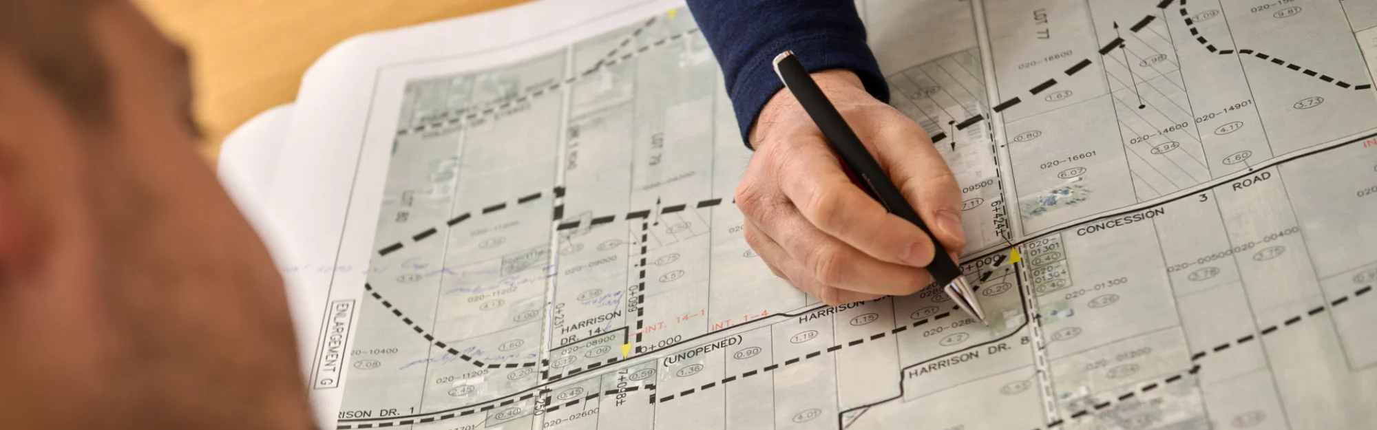 A person holding a pen over a map.